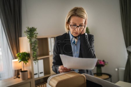Photo for Mature caucasian woman businesswoman at the office lost her job packing personal items things in box being fired from work - Royalty Free Image