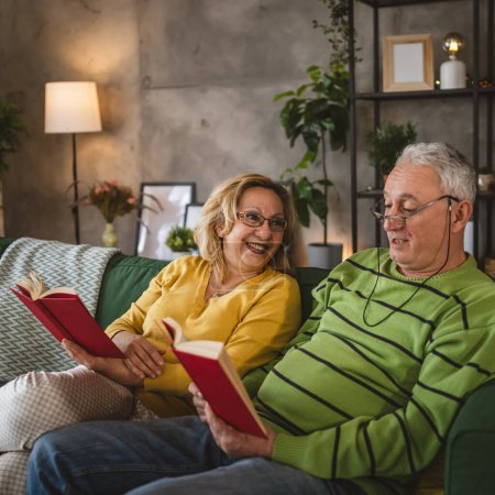 Foto de Madura pareja de ancianos marido y mujer marido y mujer leer libro en casa - Imagen libre de derechos
