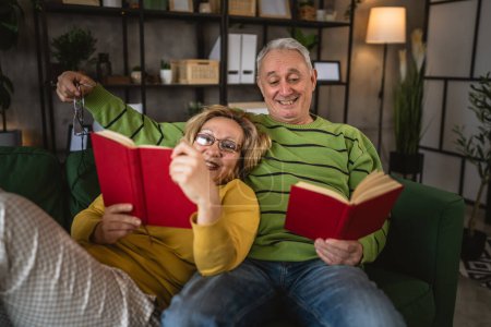 Téléchargez les photos : Mature couple âgé homme et femme mari et femme lire le livre à la maison - en image libre de droit