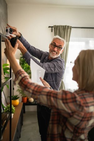 Téléchargez les photos : Couple à la maison mature ou senior caucasien mari et femme connecter et installer cctv caméra de surveillance de sécurité - en image libre de droit