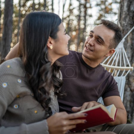 Foto de Hombre y mujer joven pareja adulta en la naturaleza celebrar y leer el libro en el amor - Imagen libre de derechos