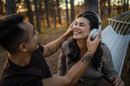 Photo for Man and woman young adult couple in nature listen music on headphones - Royalty Free Image
