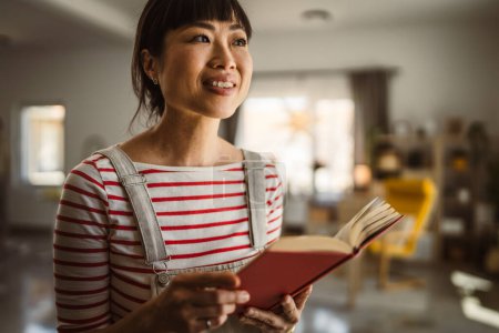 Foto de Una mujer madura japonesa mujer leer libro en casa - Imagen libre de derechos