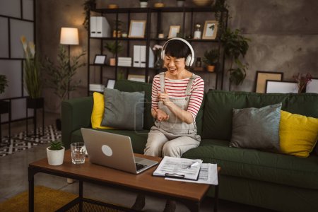 Téléchargez les photos : Femme mature japonais femme d'affaires ont appel vidéo utilisation ordinateur portable à la maison pour la consultation en ligne ou conférence - en image libre de droit