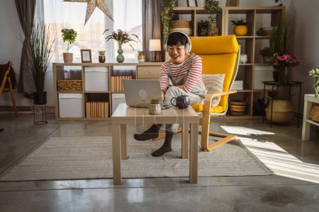 Foto de Japonesa mujer trabajo en casa en portátil y mantener el documento - Imagen libre de derechos