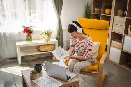 Téléchargez les photos : Japonais femme détenir document contrat de travail à la maison - en image libre de droit