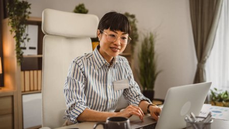 Foto de Madura japonesa mujer con gafas de trabajo en el ordenador portátil en la oficina - Imagen libre de derechos