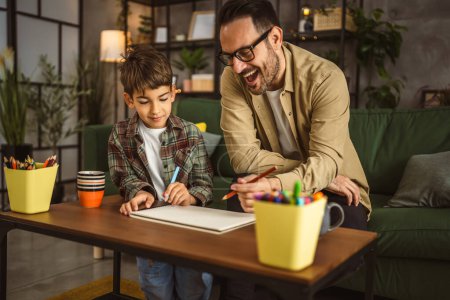 Photo for Father with eyeglasses and son caucasian draw and paint together at home leisure activity - Royalty Free Image
