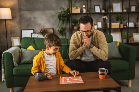 Foto de Padre con anteojos e hijo caucásico jugar juego de mesa juntos y el padre está enojado porque se pierde - Imagen libre de derechos
