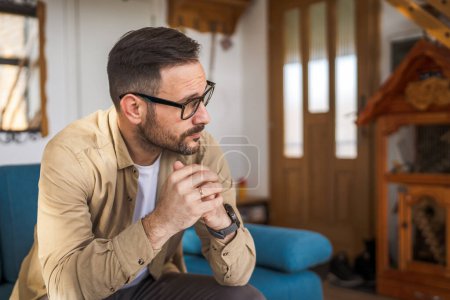 Adult worry man sit on the sofa and think about business decision at home