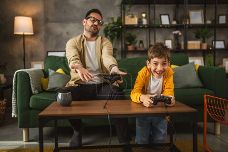 Foto de Padre e hijo caucásico jugar videojuegos con joystick y divertirse en casa feliz disfrutar - Imagen libre de derechos