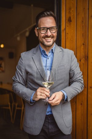 Porträt eines erwachsenen Mannes Sommelier stehen vor Weingut und halten Wein