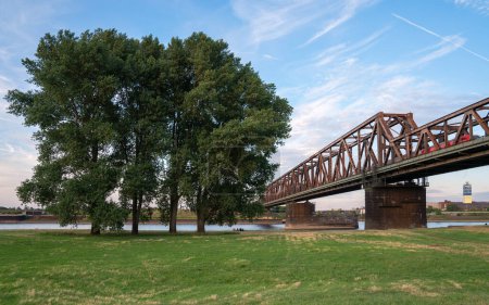 Téléchargez les photos : DUISBURG, ALLEMAGNE - 13 JUILLET 2022 : Ancien pont traversant le Rhin au coucher du soleil le 13 juillet 2022 à Duisburg, Allemagne - en image libre de droit