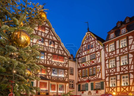 Foto de BERNKASTEL-KUES, ALEMANIA - 17 DE DICIEMBRE DE 2022: Mercado de Navidad, ciudad de Mosell Bernkastel-Kues con árbol de Navidad y casas de entramado de madera el 17 de diciembre de 2022 en Alemania - Imagen libre de derechos