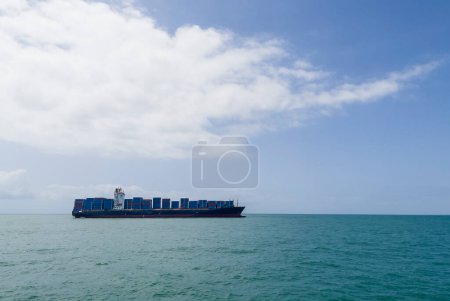 Containerschiff oder Containerschiff beladen mit Containerfracht auf den Wellen des Indischen Ozeans in der Nähe des Seehafens Sansibar. Containerschifffahrt und transkontinentales Geschäftskonzept Foto.