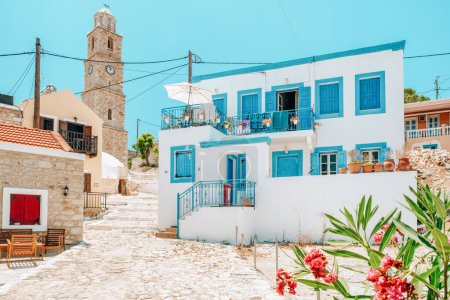 Foto de Halki, Grecia - 6 de julio de 2022: Casa tradicional griega blanca con persianas azules en un pequeño pueblo en la isla Halki, Grecia - Imagen libre de derechos