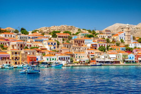 Foto de Halki, Grecia - 6 de julio de 2022: Casas coloridas en la pequeña isla pintoresca Halki (Chalki) en el mar Egeo, parte de las islas del Dodecaneso en Grecia - Imagen libre de derechos