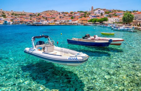 Foto de Halki, Grecia - 6 de julio de 2022: Barcos en el mar Egeo en el puerto de la aldea de pescadores en la isla Halki (Chalki) en Grecia - Imagen libre de derechos