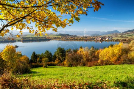 Téléchargez les photos : Paysage automnal coloré avec lac, arbres jaunes et montagnes en arrière-plan. - en image libre de droit