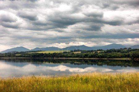 Photo for Reflection of clouds on the water surface. Mountains at background - Royalty Free Image