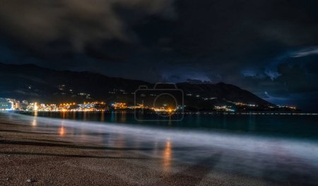 Cielo nocturno sobre el mar Adriático y la playa de arena en el complejo Becici en Montenegro.