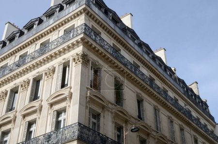 Foto de Ventanas y barandillas de hierro decoradas en balcones en la fachada de edificios residenciales en París, Francia. - Imagen libre de derechos
