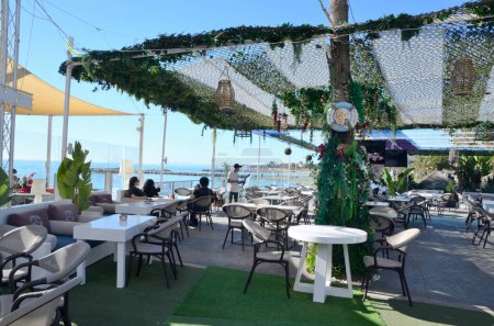 Téléchargez les photos : Marbella, Espagne - 10 décembre 2023 : Les gens mangent sur la terrasse pittoresque du restaurant Banus Port, à Marbella, Espagne. - en image libre de droit