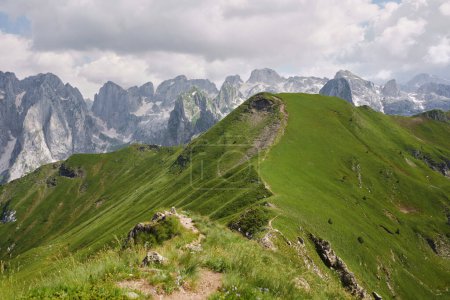 Caminata cumbre con amplias vistas a la montaña. La cresta de una cresta de montaña verde ofrece una perspectiva impresionante sobre una sucesión de picos bajo un cielo despejado