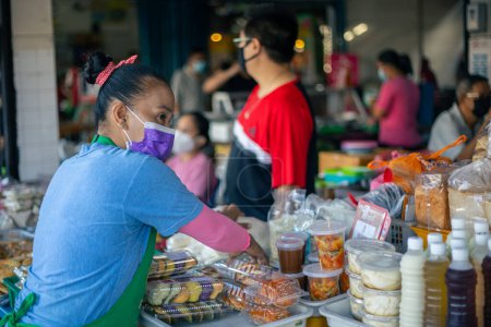Téléchargez les photos : Kota Kinabalu, Sabah, Malaisie 7 août 2021 : Image franche de l'acheteur et du vendeur portant un masque facial aux ingrédients locaux stalle de nourriture fraîche sur un nouveau mode de vie normalisé pendant la pandémie Covid-19 - en image libre de droit