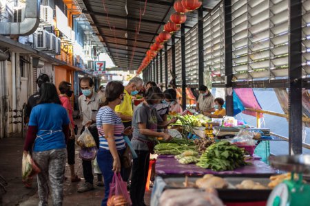 Foto de Kota Kinabalu, Sabah, Malasia 7 de agosto de 2021: Imagen franca del comprador y vendedor que usa mascarilla en el puesto de comida fresca de los ingredientes locales en un estilo de vida de Nueva norma durante Pandemic Covid-19 - Imagen libre de derechos