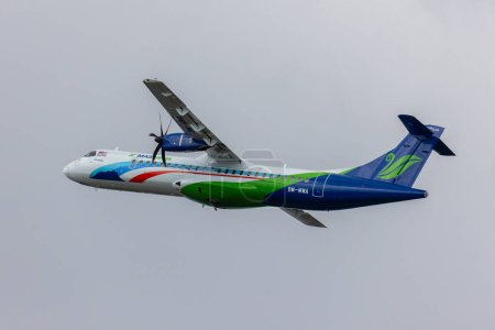 Téléchargez les photos : Kota Kinabalu, Sabah, Malaisie-16 août 2021 : Maswing Airlines ATR-72-500 volant dans le ciel bleu clair - en image libre de droit