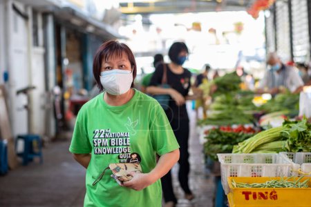 Téléchargez les photos : Kota Kinabalu, Sabah, Malaisie 7 août 2021 : Image franche de l'acheteur et du vendeur portant un masque facial aux ingrédients locaux stalle de nourriture fraîche sur un nouveau mode de vie normalisé pendant la pandémie Covid-19 - en image libre de droit