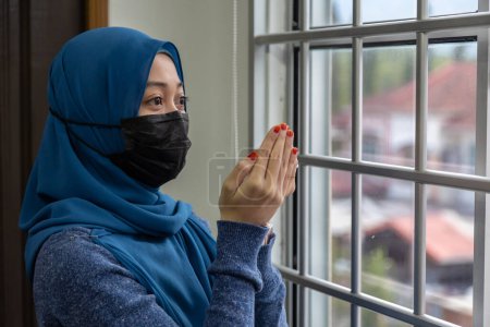Téléchargez les photos : Musulmane religion islamique femme priant tout en portant un masque médical pour prévenir Corana Covid-19 Virus - en image libre de droit
