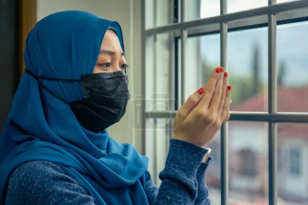 Téléchargez les photos : Musulmane religion islamique femme priant tout en portant un masque médical pour prévenir Corana Covid-19 Virus - en image libre de droit
