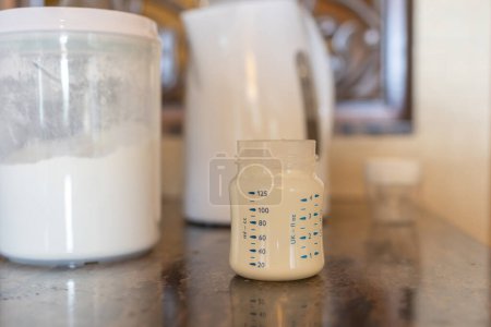Foto de Preparing baby bottle of powdered milk on table - Imagen libre de derechos