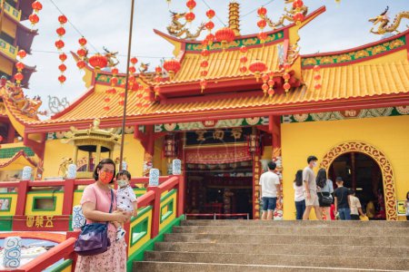 Téléchargez les photos : Kota Kinabalu, Sabah, Malaisie-2 février 2022 : Image du point de vue de la mère chinoise locale porter son fils avec masque médical voir sur la caméra au temple chinois pendant le Nouvel An chinois. - en image libre de droit