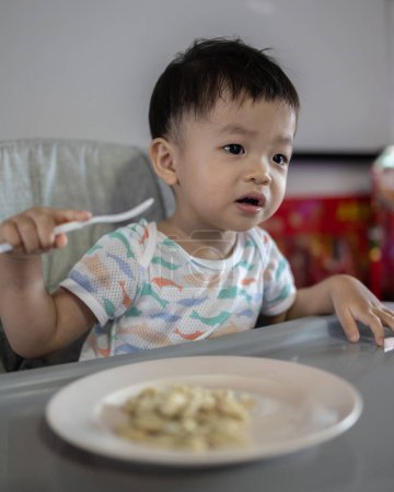 Photo for Happy 1-2 years old child enjoying his lunch - Royalty Free Image