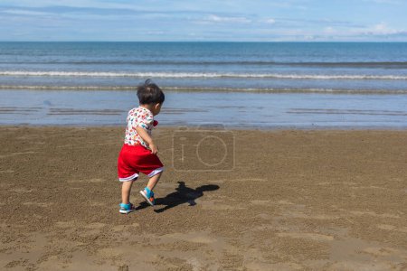 Foto de Niño feliz pasándolo bien y corriendo en la playa - Imagen libre de derechos