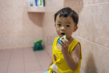 Foto de Asiático chico aprender a cepillarse los dientes - Imagen libre de derechos