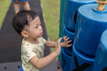Téléchargez les photos : Portrait de garçon asiatique au parc aire de jeux - en image libre de droit