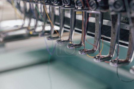 Téléchargez les photos : Extrême gros plan de broderie aiguille de machine dans l'industrie textile chez les fabricants de vêtements, aiguille de broderie, aiguille avec fil - en image libre de droit