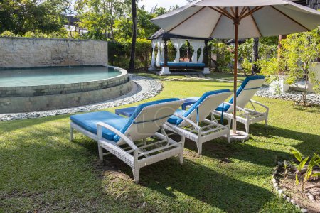 Téléchargez les photos : Chaises de plage ou lits de piscine avec belle villa - en image libre de droit