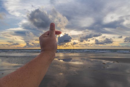 Téléchargez les photos : Homme main amour signe avec magnifique coucher de soleil avec nuage dramatique - en image libre de droit