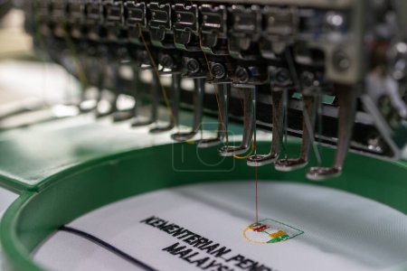 Foto de Kota Kinabalu, Sabah, Malasia-20 de septiembre de 2022: Máquinas de bordar que funcionan rápido en la industria textil en los fabricantes de prendas de vestir Kota Kinabalu, Sabah, Malasia. - Imagen libre de derechos