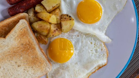 Foto de Preparación Desayuno por la mañana con huevos fritos y salchichas sirven en el plato. - Imagen libre de derechos