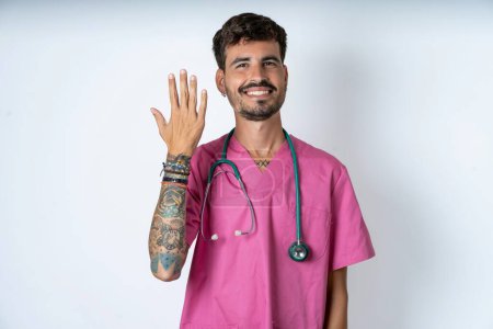 Photo for Handsome nurse man wearing surgeon uniform over white background smiling and looking friendly, showing number five or fifth with hand forward, counting down - Royalty Free Image