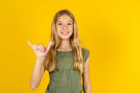 Photo for Blond little girl wearing khaki blouse over yellow background showing up number six Liu with fingers gesture in sign Chinese language - Royalty Free Image
