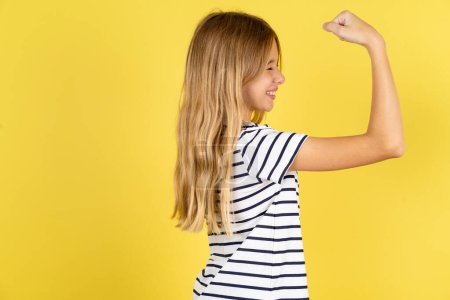 Photo for Profile photo of beautiful caucasian teen girl wearing striped T-shirt over yellow background supporting soccer team World Cup 2022 raise fist shouting - Royalty Free Image