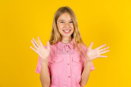 Foto de Loca muchacha indignada con chaqueta rosa sobre fondo amarillo grita en voz alta y gestos airadamente grita furiosamente. Emociones humanas negativas sentimientos concepto - Imagen libre de derechos