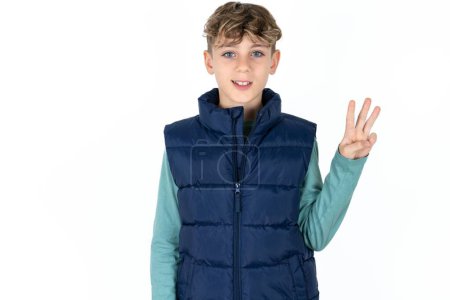 Photo for Handsome Caucasian teen boy in blue vest showing and pointing up with fingers number three while smiling confident and happy. - Royalty Free Image